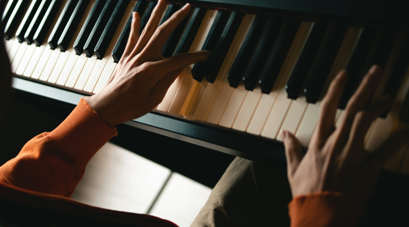 mão masculina tocando piano.