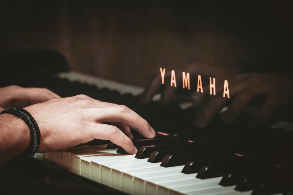 mão de homem sobre as teclas de piano yamaha.