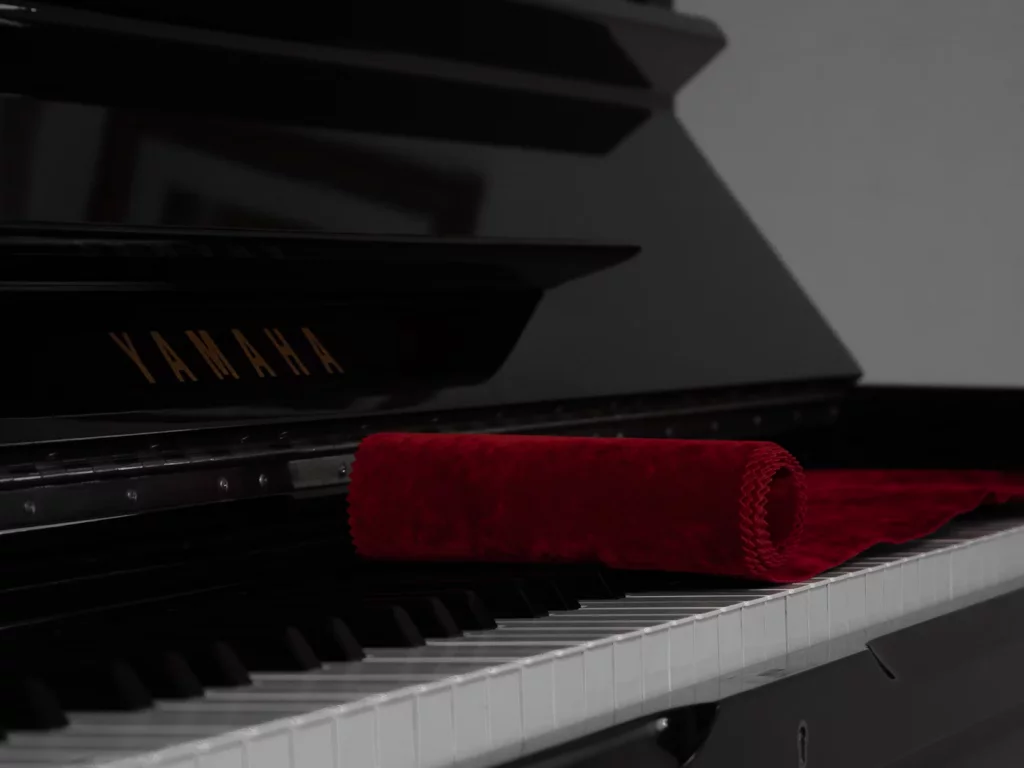 pianos famosos, modelo yamaha com pano vermelho acima das teclas.