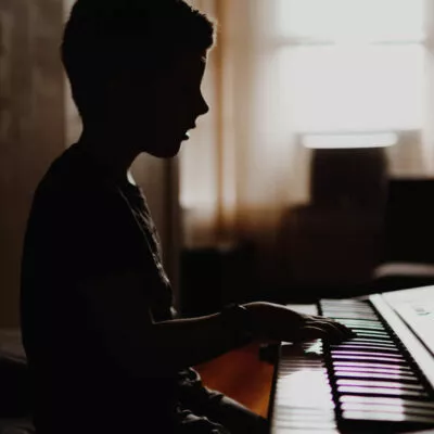 Criança estudando piano.